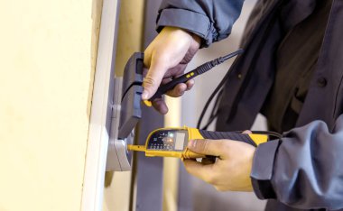 Sarı bir arka plan üzerinde bir çift çıkış kabloları bağlantı denetimi işlemi