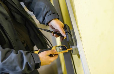 Sarı bir arka plan üzerinde bir çift çıkış kabloları bağlantı denetimi işlemi