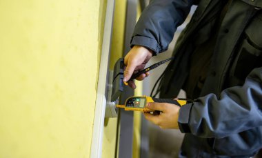 Sarı bir arka plan üzerinde bir çift çıkış kabloları bağlantı denetimi işlemi