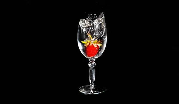 Erdbeeren Fallen Ein Glas Wasser Auf Schwarzem Hintergrund — Stockfoto