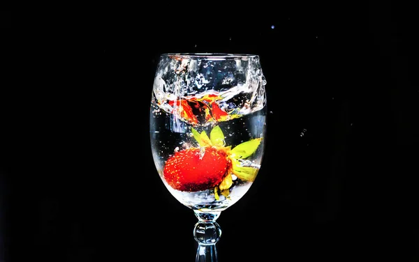 Erdbeeren Fallen Ein Glas Wasser Auf Schwarzem Hintergrund — Stockfoto