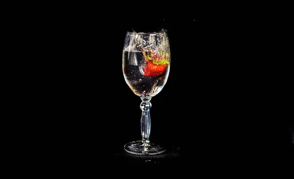 Erdbeeren Fallen Ein Glas Wasser Auf Schwarzem Hintergrund — Stockfoto