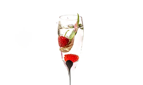 在一杯香槟酒中落下覆盆子的过程 在白色的背景上有水 — 图库照片