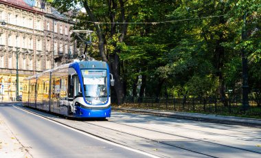 Modern tramvay şehrin yeşil park fon karşı sokaklarında