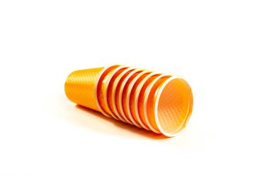 Turuncu plastik bardak birer birer beyaz zemin üzerine dizilir