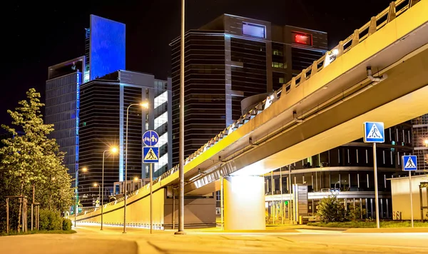Elevated Road bridge on the background of office buildings in the city at night