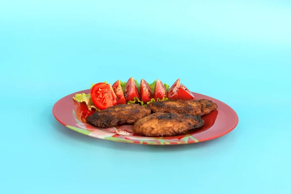 Klopsiki z sałatką i pomidorami w talerzu na turkusowym grzbiecie — Zdjęcie stockowe
