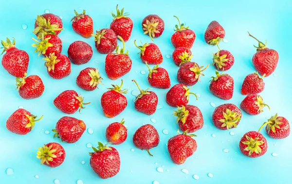 Die Textur ist Erdbeere mit Wassertropfen in türkisfarbener Farbe — Stockfoto
