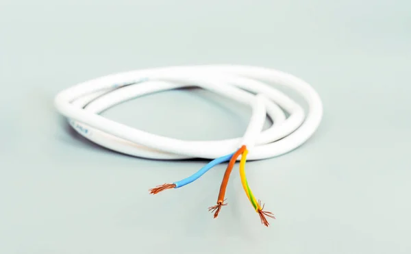 Трехъядерный кабель в белой изоляции на сером фоне — стоковое фото