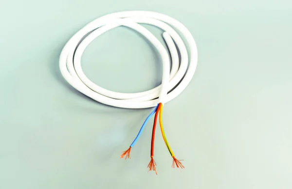 Трехъядерный кабель в белой изоляции на сером фоне — стоковое фото