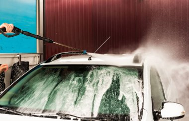 Bir basınç yıkayarak beyaz bir araba yıkama işlemi