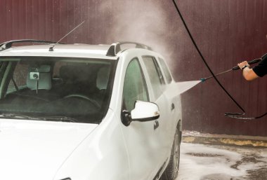 Bir basınç yıkayarak beyaz bir araba yıkama işlemi