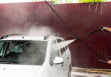 Bir basınç yıkayarak beyaz bir araba yıkama işlemi