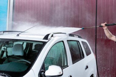 Bir basınç yıkayarak beyaz bir araba yıkama işlemi