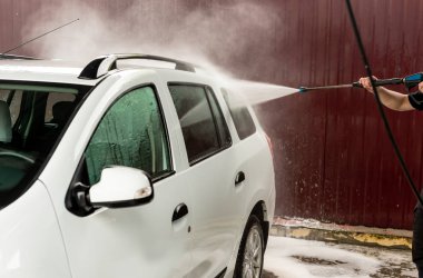Bir basınç yıkayarak beyaz bir araba yıkama işlemi