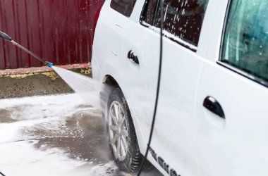 Bir basınç yıkayarak beyaz bir araba yıkama işlemi