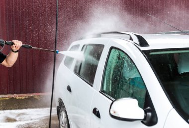 Bir basınç yıkayarak beyaz bir araba yıkama işlemi