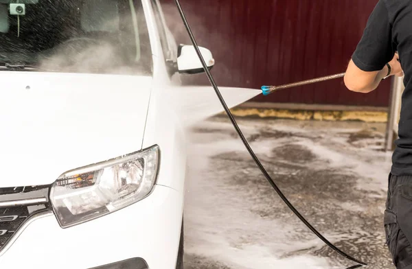 Il processo di lavaggio di un'auto bianca con una rondella a pressione — Foto Stock