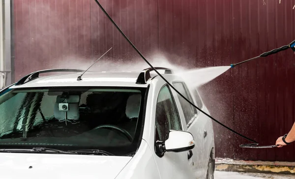 Bir basınç yıkayarak beyaz bir araba yıkama işlemi