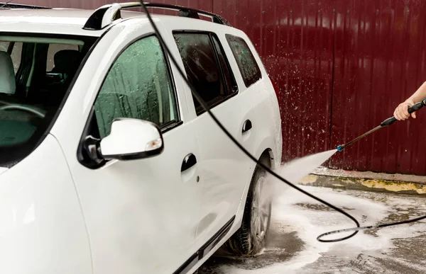 Le processus de lavage d'une voiture blanche à l'aide d'un lave-pression — Photo