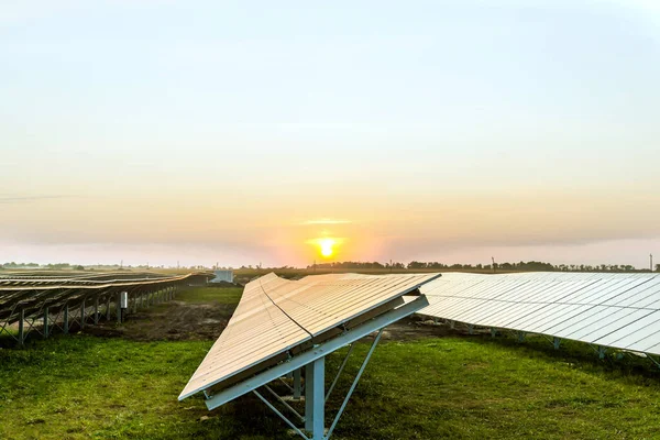 日没の背景に太陽電池パネルの行 — ストック写真