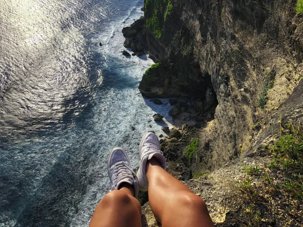 First-person view of Uluwatu cliff with pavilion and blue sea in Bali, Indonesia