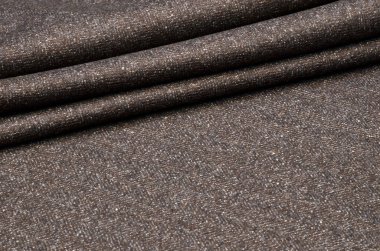 Takım elbise, tüvit yün kahverengi-gri kumaştır.