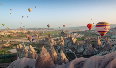 Kapadokya Türkiye 'de kayaların üzerinde uçan sıcak hava balonu 