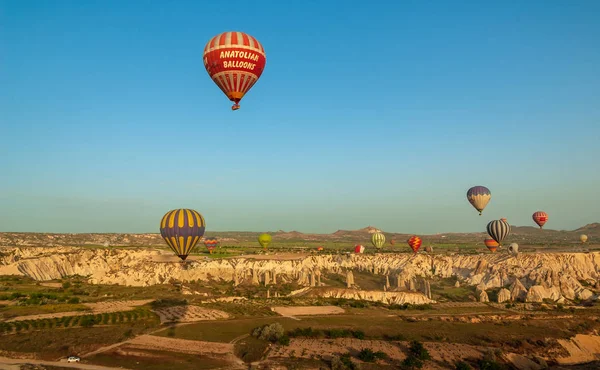 Globo de aire caliente volando sobre el paisaje rocoso en Capadocia Turquía — Foto de Stock