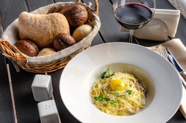 Makarna Carbonara parmesan ve beyaz arka plan üzerinde sarısı ile beyaz plaka üzerinde