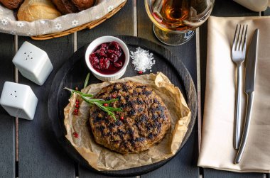 Sığır köftesi ahşap bir masa üzerinde ahşap bir tabak tabaktabak servis