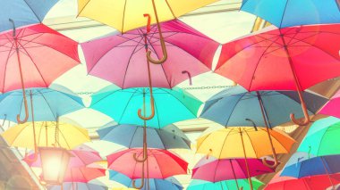 Sokakta asılı renkli gökkuşağı renkli şemsiyeler