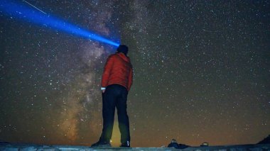 Gece gökyüzüne ve Samanyolu 'na ışık tutan bir adam..