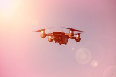 Mavi gökyüzü arka planına sahip uçan dron fotoğrafçı tarafından kontrol ediliyor.