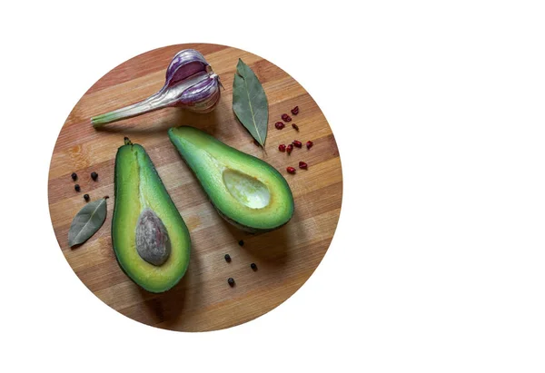 Avocado Tagliato Metà Giace Sul Tagliere Con Aglio Fresco Spezie — Foto Stock