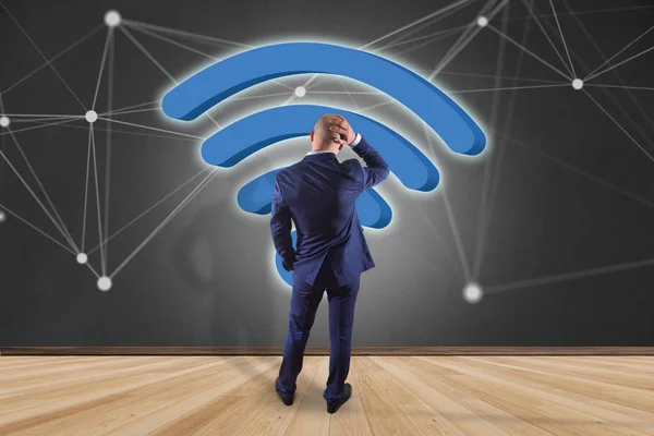 未来的なインターフェースの接続とインターネットに表示される Wifi 記号が付いている壁の前で実業家のビュー — ストック写真