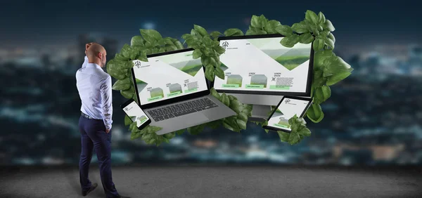View of a Businessman in front of Connected devices surrounding by leaves 3d rendering