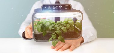 Bağlı bir dijital bitkisel bitki tutan bir Businesmann görünümünü 