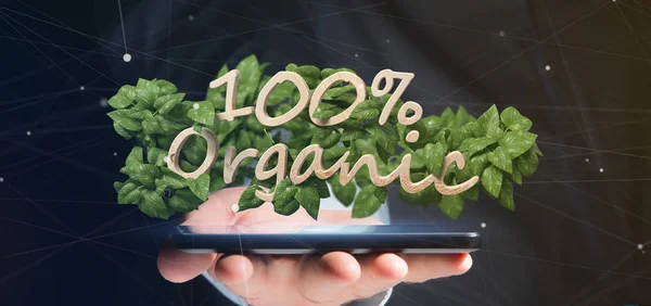 Businessman holding a Wooden logo 100 % organic with leaves arou — Stock Photo, Image