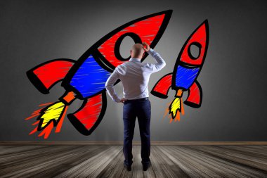 Bir duvarın önünde renkli bir başlangıç düşünen işadamı 