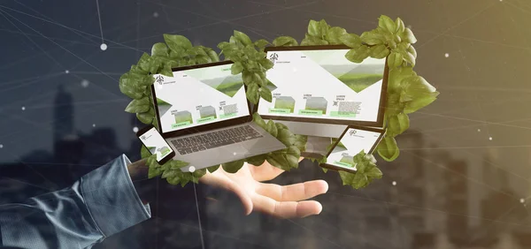 Businessman holding a Connected devices surrounding by leaves 3d