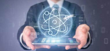 Veri ile çevrili bir atom simgesi tutan işadamı
