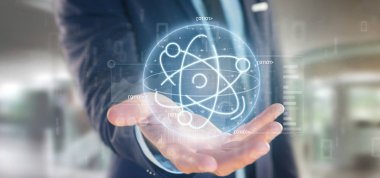 Veri ile çevrili bir atom simgesi tutan işadamı