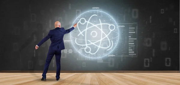 Businessman holding an atom icon surrounded by data — Stock Photo, Image