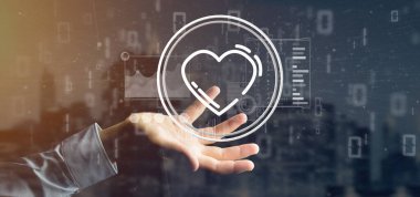 Veri ile çevrili bir kalp simgesi tutan işadamı