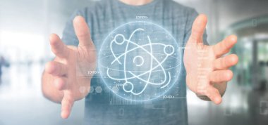 Veri ile çevrili bir atom simgesi tutan işadamı