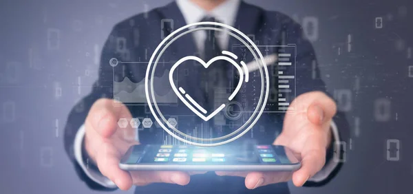 A szív ikonnal rendelkező üzletember az adatokkal körülvéve — Stock Fotó
