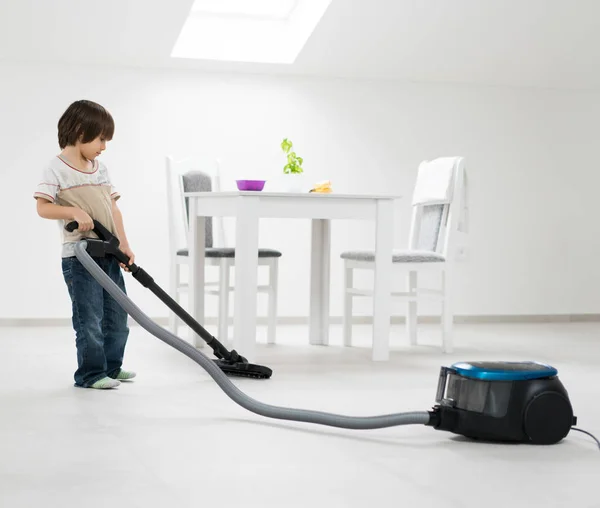 Pequeño niño haciendo aspiradora en casa en interiores —  Fotos de Stock