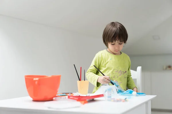 Маленький хлопчик вдома малює і грає — стокове фото