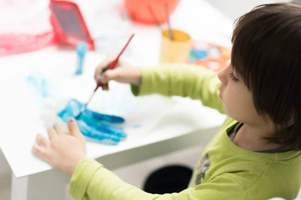 Menino em casa desenhando e brincando — Fotografia de Stock